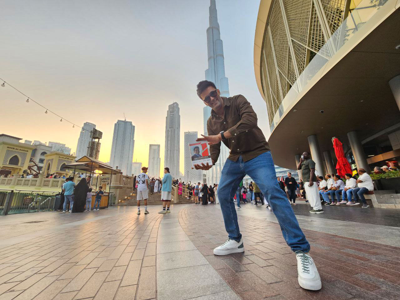 Jitendra Vaswani holding his book in front of the Burj Khalifa in Dubai