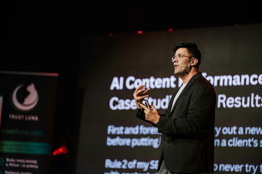 Jitendra Vaswani on stage presenting AI content performance case study results
