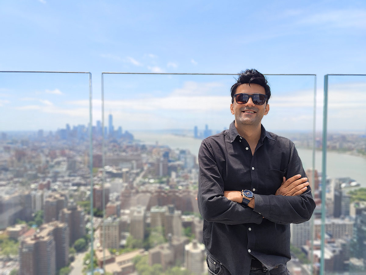 Jitendra Vaswani on a New York rooftop with the Manhattan skyline behind him