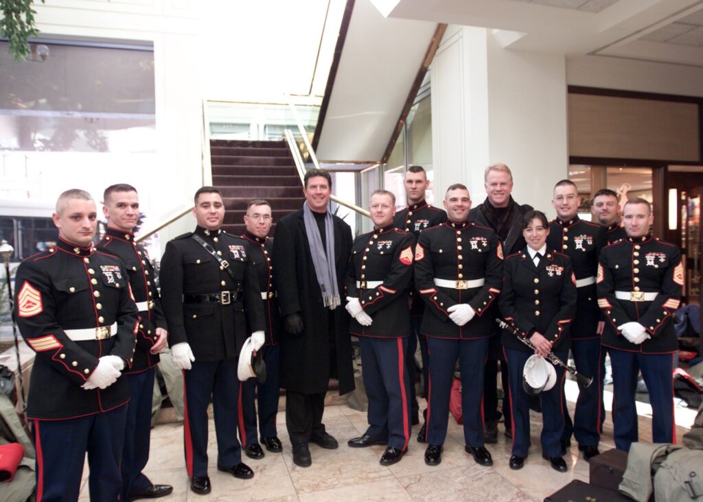 Boomer Esiason and Dan Marino meeting a Marine Corps band, linked to Boomer Esiason net worth and NFL fame