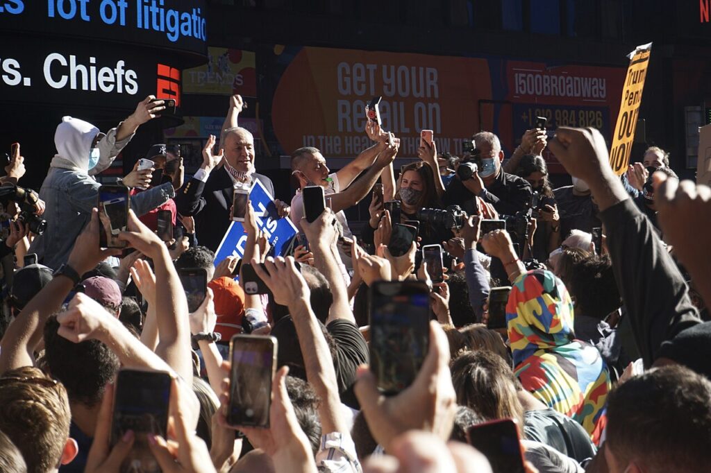 Chuck Schumer speaking to a crowd in Times Square, New York, the state behind his net worth and career